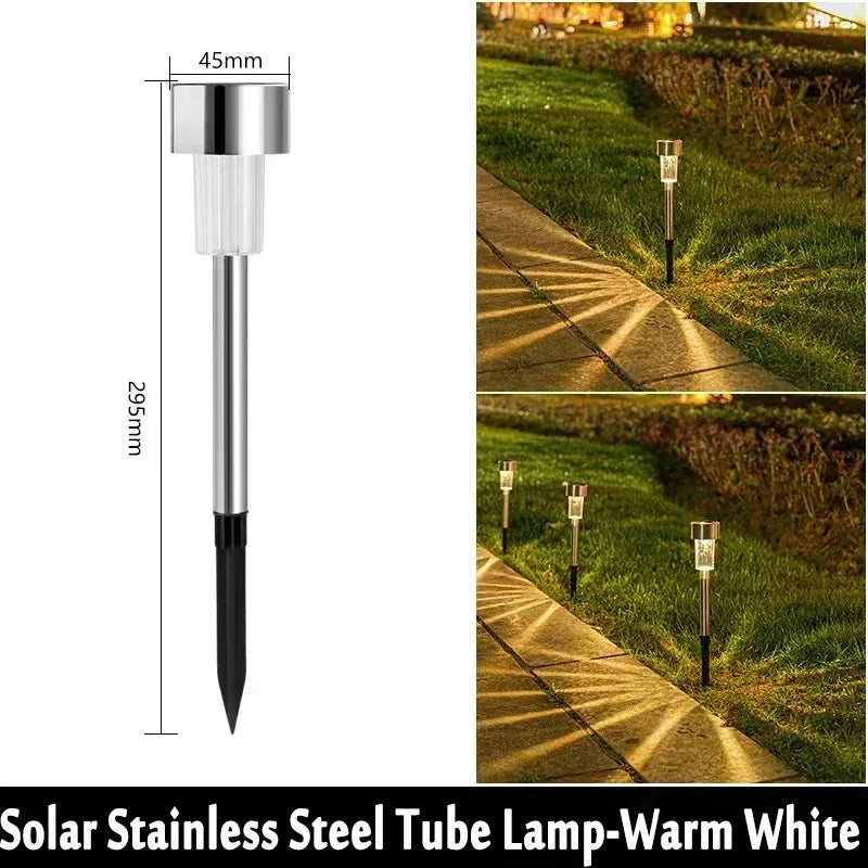 A vertical tube lamp with a silver finish used as an outdoor pathway light in a grassy landscape.