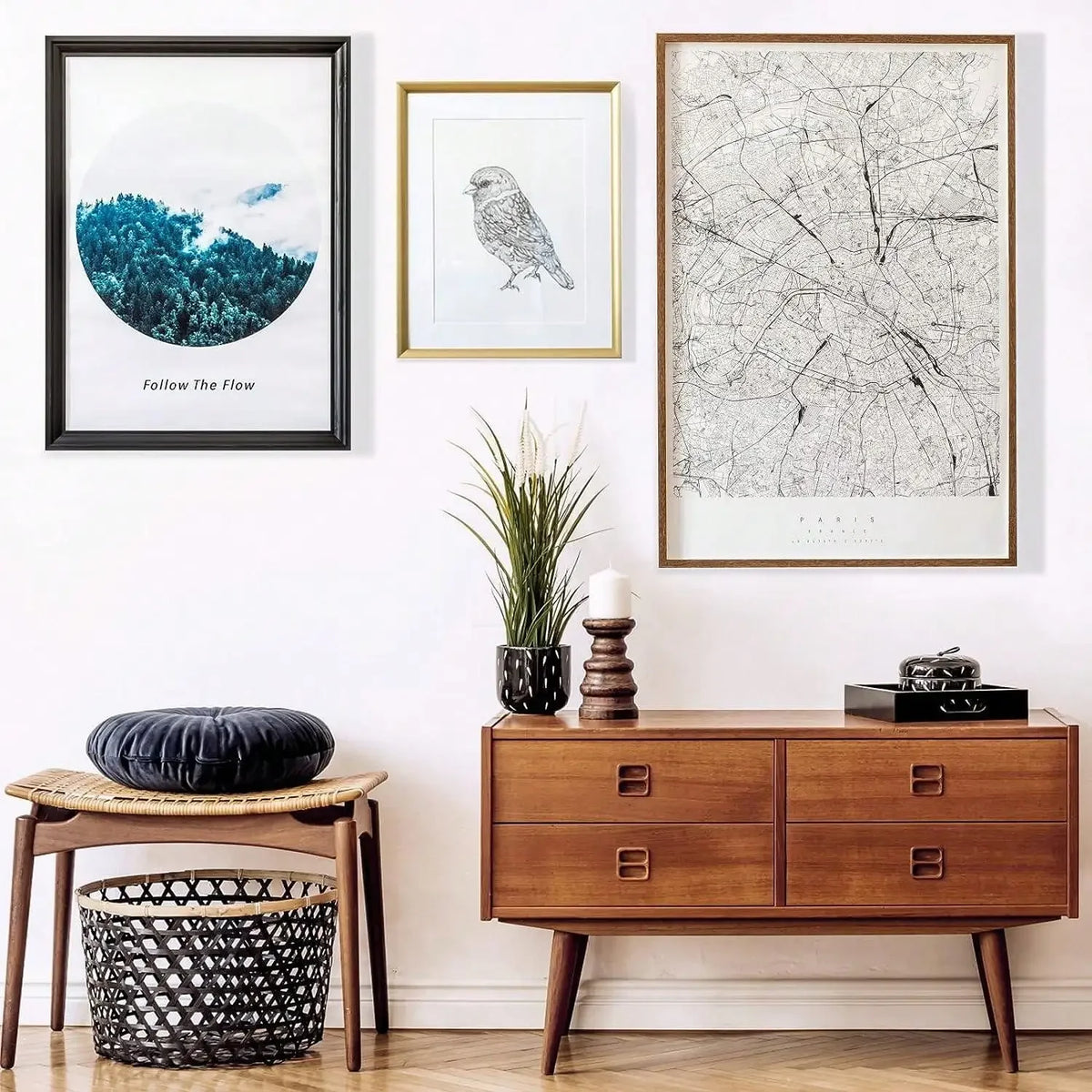 A display featuring a framed nature print, a line art drawing, and a wooden cabinet with decorative items.