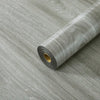 Rolle realistischer Holzmaserung PVC-Wandsticker auf grauer Oberfläche.