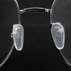 Clear silicone eyeglass nose pads with a screwdriver tool shown against a dark background