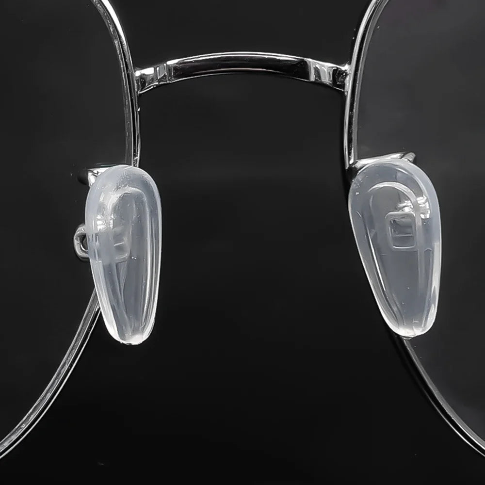 Clear silicone eyeglass nose pads with a screwdriver tool shown against a dark background