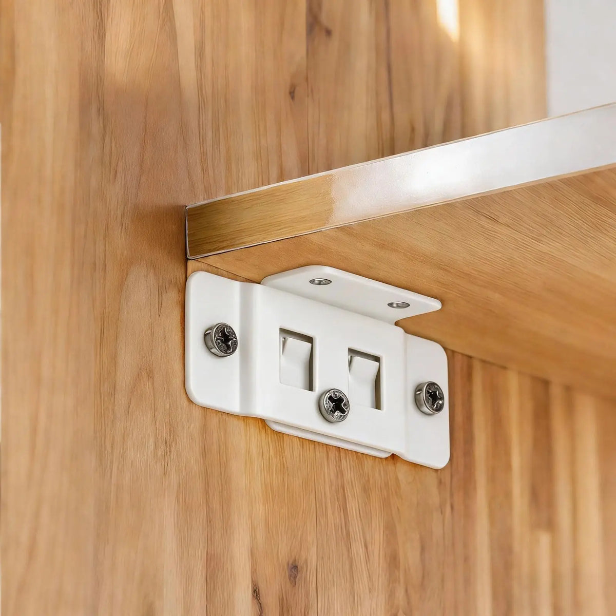 Heavy-duty stainless steel corner brackets mounted on a wooden cabinet joint.