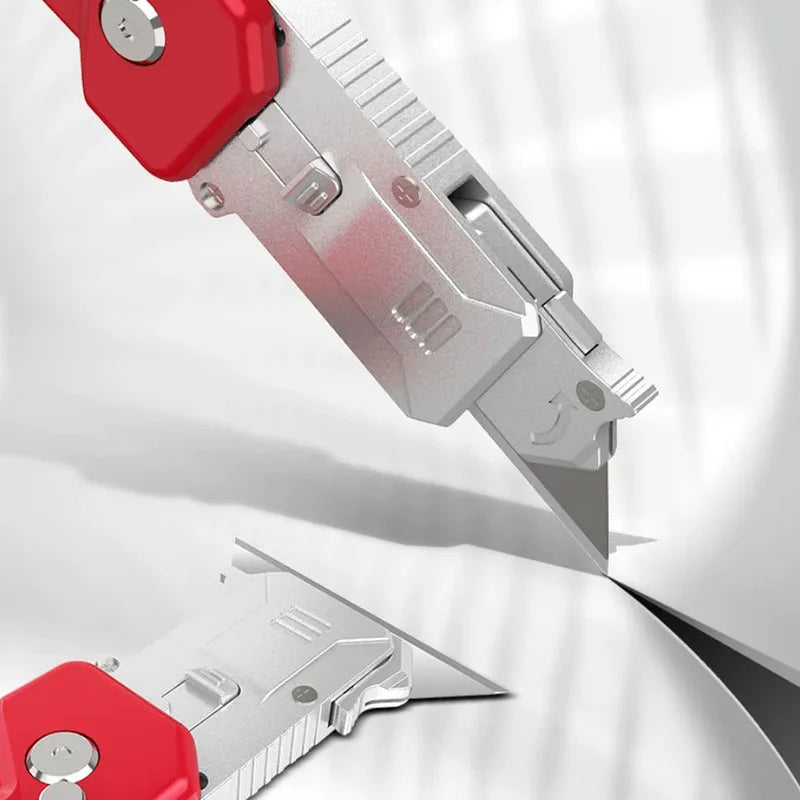 A close-up view of a silver utility knife with a red handle, showing the blade and folding mechanism.