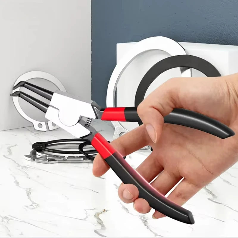 A hand holds a white and red precision multifuntional pliers used for retaining rings and shafts.