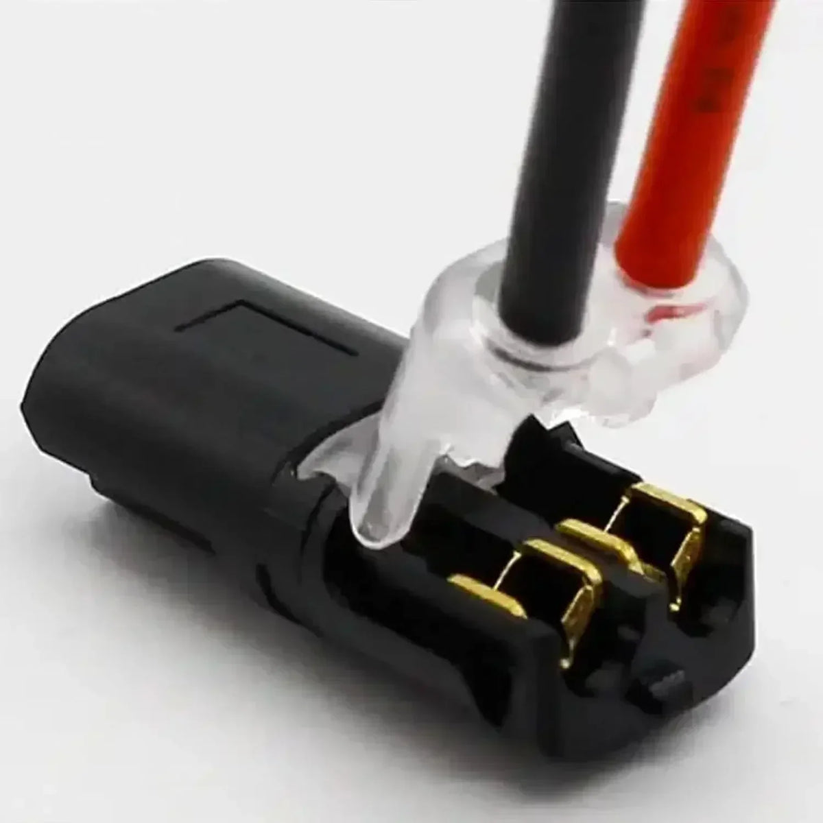 A close-up view of a black plug with clear insulation and red wires, showing crimp terminals for wire connectors.