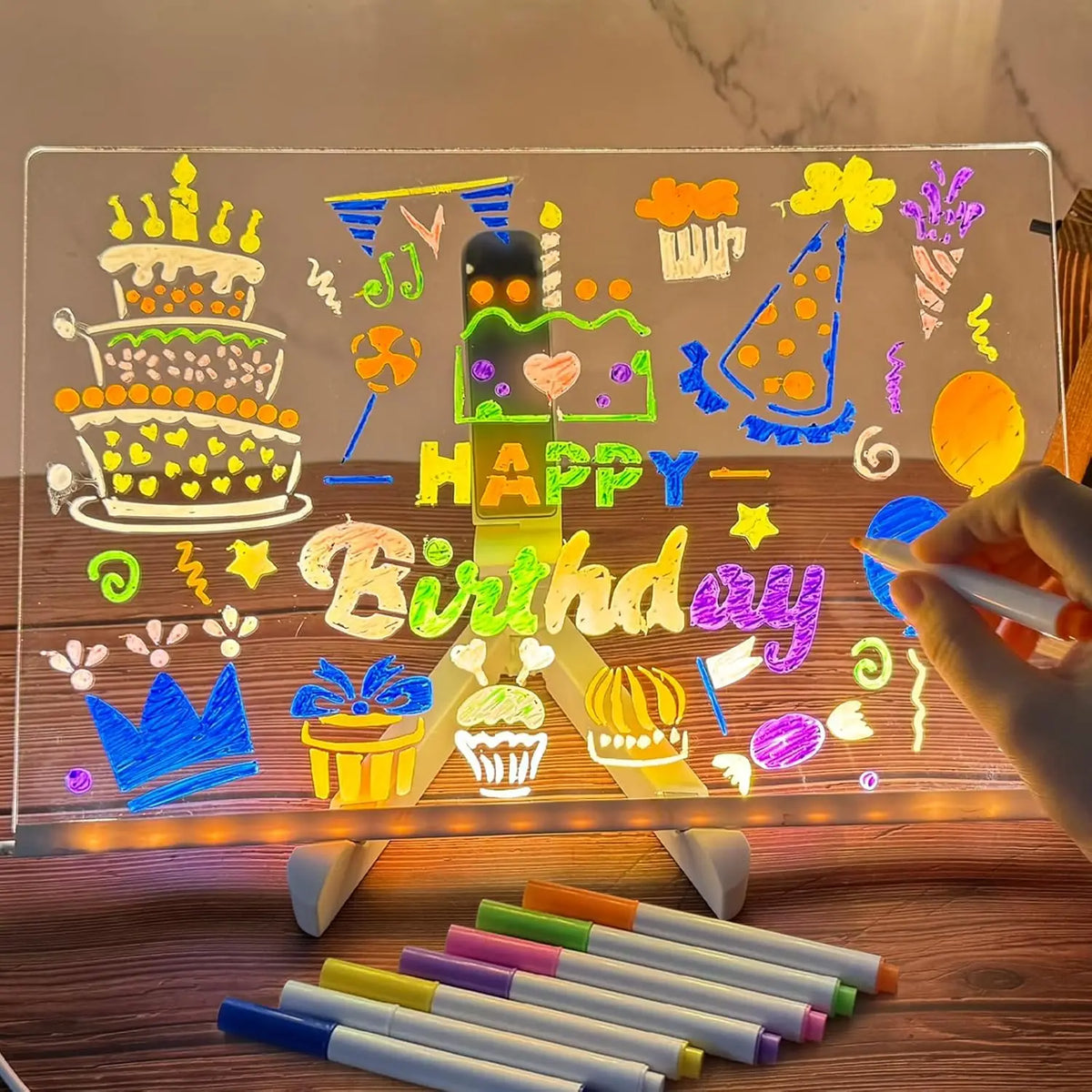 An LED acrylic message board displays a birthday message and various colorful decorations lit by a built-in night light.