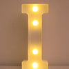 Luz nocturna de letra I amarilla brillante LED iluminando una superficie blanca.