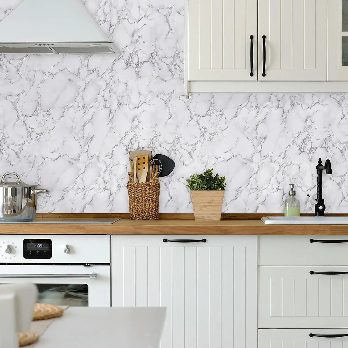 A kitchen cabinet and countertop featuring white shaker cabinets and a marble backsplash with pink veining.