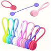 Un jeu de trois attaches de câble en silicone magnétiques de diverses couleurs pastel, dont rose, violet et vert.