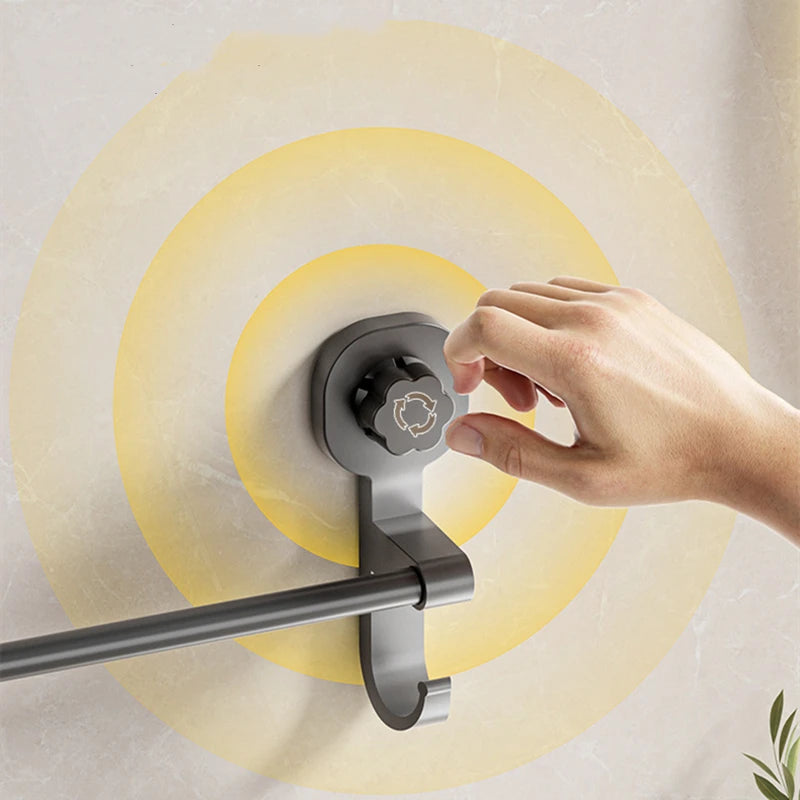 A hand is adjusting a durable adhesive towel rack mounted on a wall with concentric yellow circles.