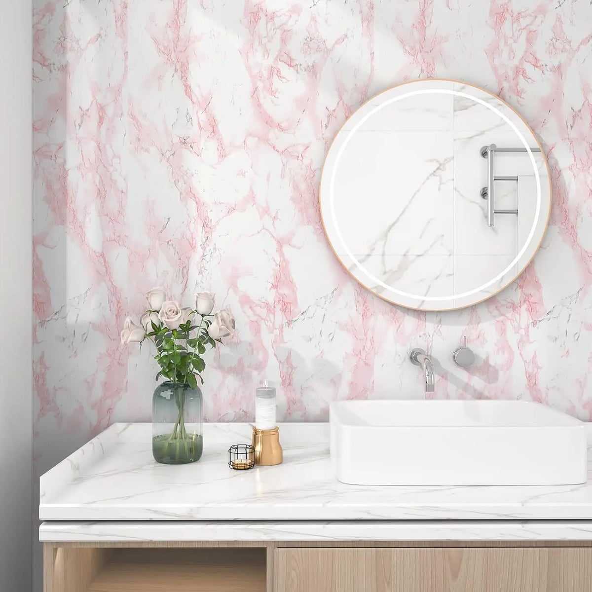 A bathroom vanity featuring a white sink and mirror against a pink marble-patterned wall.