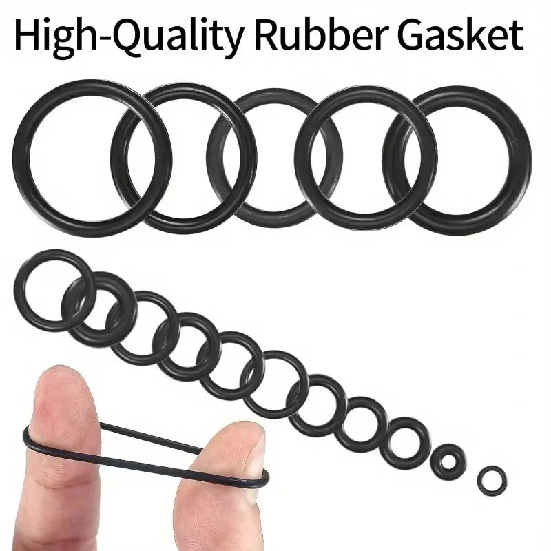 A set of black rubber gaskets, including O-rings and a chain of rings, shown next to a human finger.