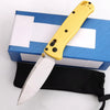 Un couteau de poche pliable jaune posé sur une boîte bleue avec des accents blancs.