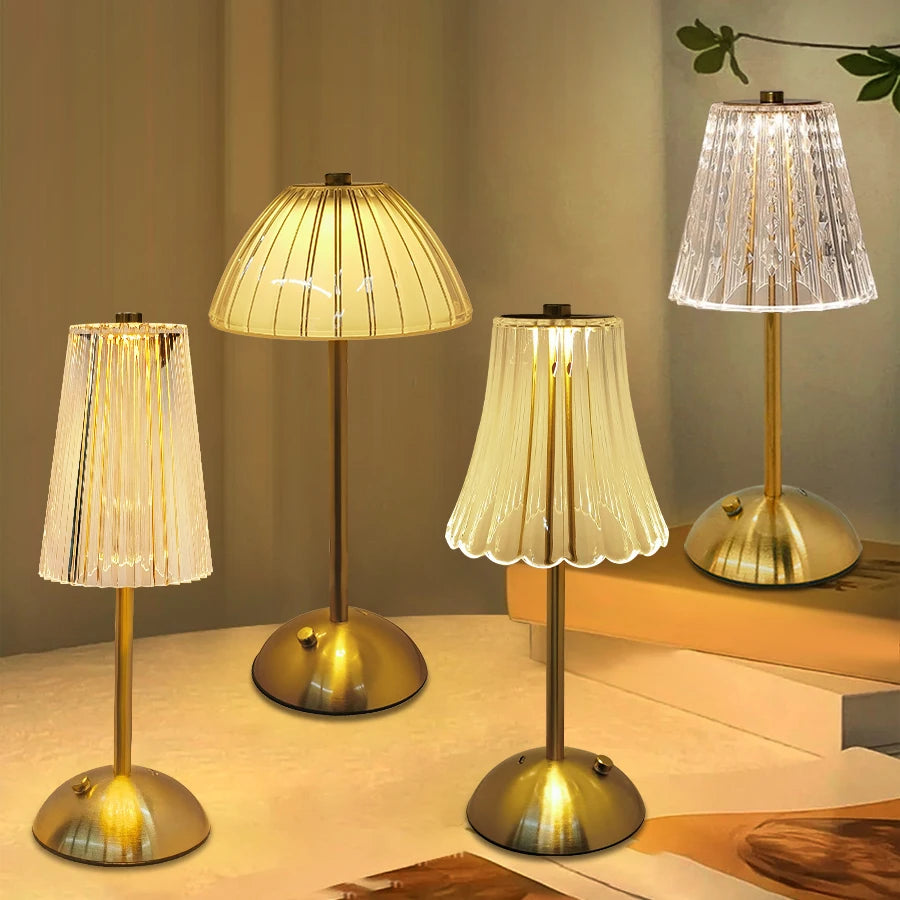 A set of three brass-toned desktop reading lamps with translucent shades illuminating a wooden surface.