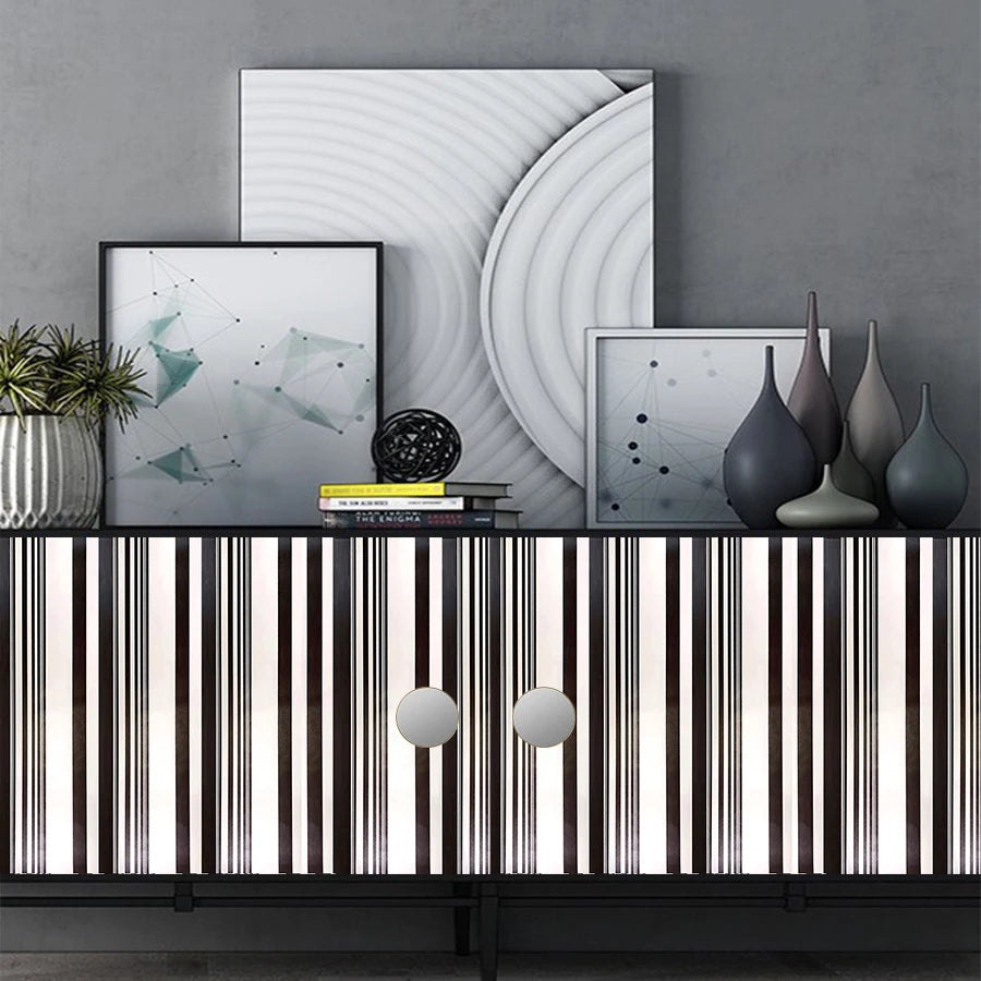 A display of decorative vinyl wall strips in various shades and widths, featuring abstract artwork in the background.