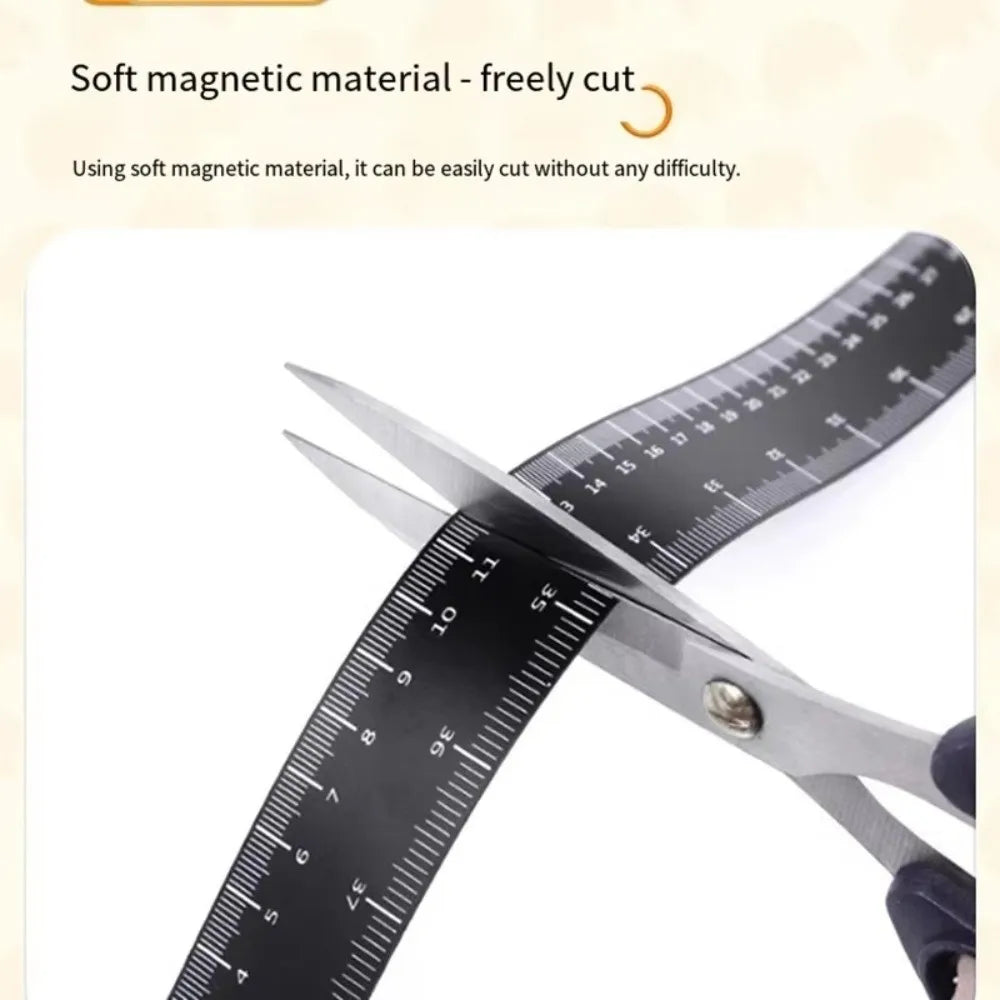 A pair of silver scissors cutting through a black magnetic dual scale flexible measuring ruler.