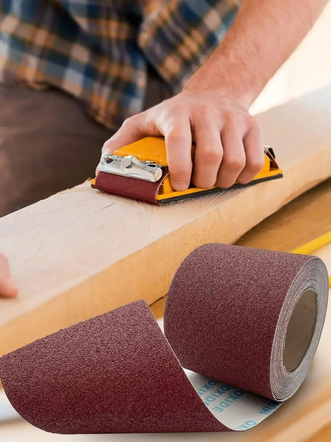 A hand is holding an aluminum oxide sandpaper roll, showing the reddish-brown abrasive material.