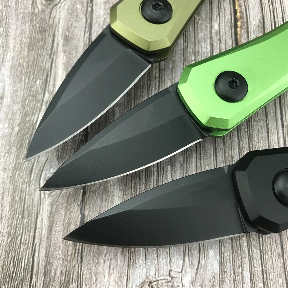 Un couteau de survie pliable compact avec une poignée verte et une lame noire posé sur une surface en bois.