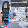 A hand holds a blue and black clamp meter for temperature measurement in an industrial setting.