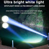 A bright white spotlight mode flashlight beam cuts through the darkness onto a body of water and surrounding foliage.