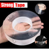Roll of clear double-sided mounting tape being applied to a hand for demonstration.