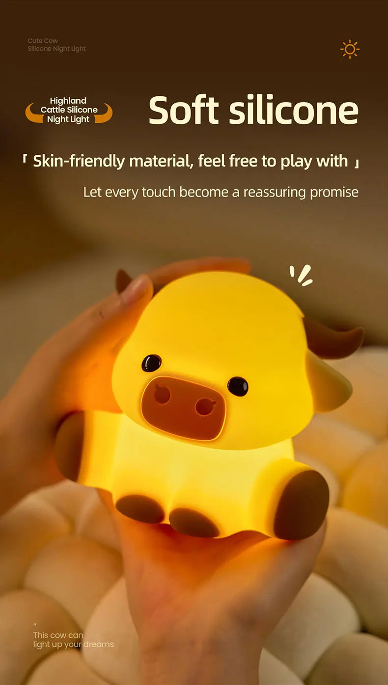 A hand holds a soft silicone night light shaped like a yellow Highland cow.