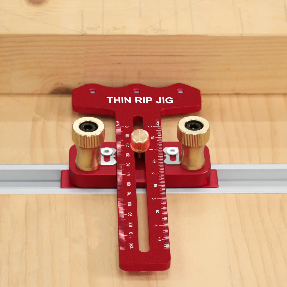 A red precision thin rip jig for a table saw, featuring a measuring scale and two guide rollers.