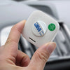 A hand holds a white compact digital temperature and humidity gauge with a green QC passed sticker.