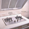 Gros plan d'une cuisinière avec des autocollants transparents anti-graisse sur les brûleurs et des autocollants en aluminium 