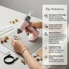 A hand is using a pink cordless hot glue gun to apply glue, demonstrating its features and design.