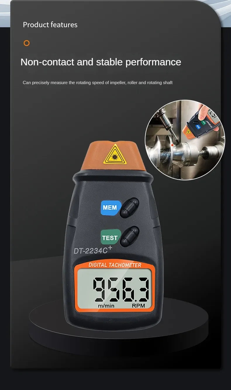 A black digital tachometer measuring 956.3 RPM, used for non-contact measurement of rotating shaft speed.