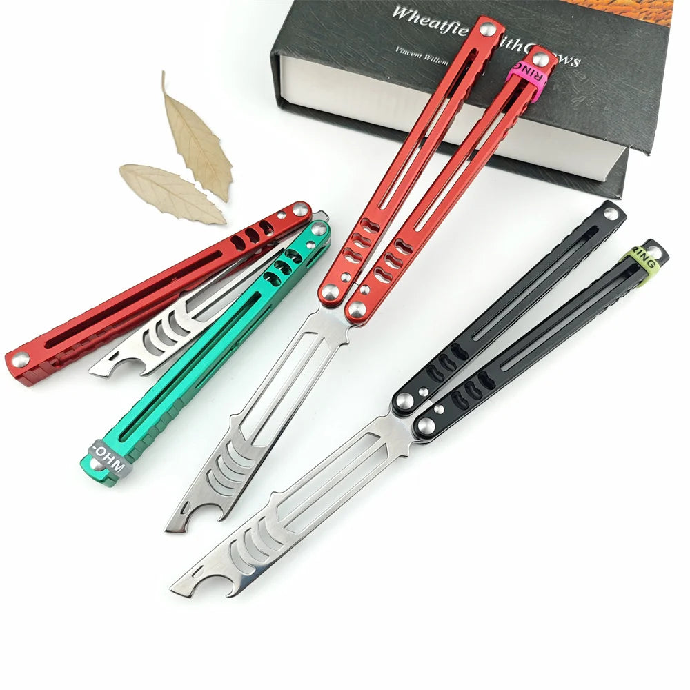 A set of folding tactical pen knives in red, silver, and black are displayed next to a book.