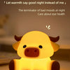 A yellow Highland cow night light lamp illuminating a surface.
