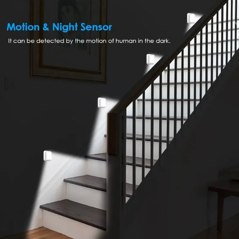 A motion and night sensor light mounted on a staircase railing, illuminating the stairs in a dark hallway.