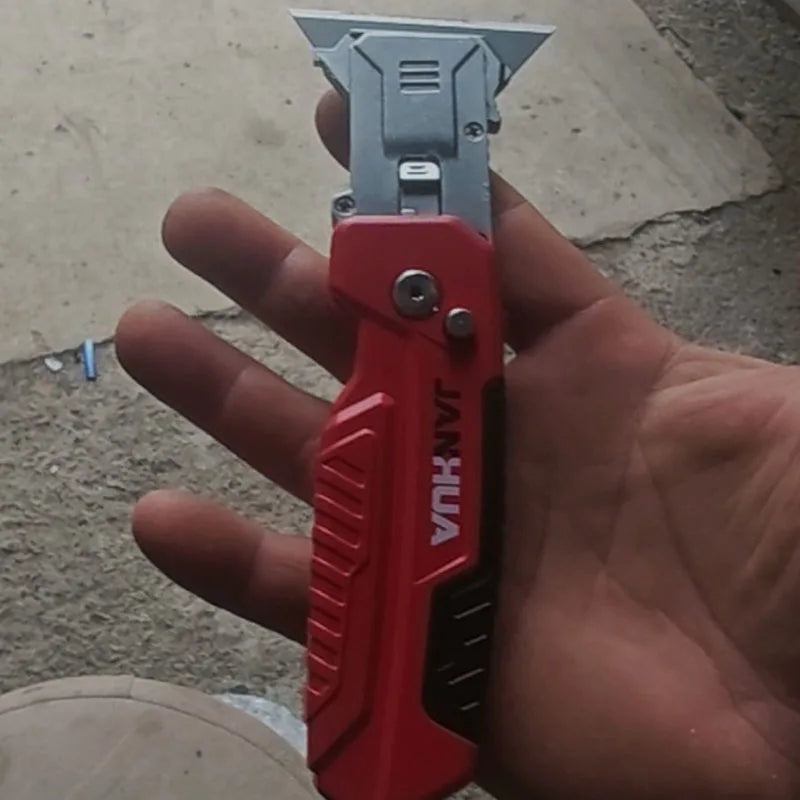 A hand holds a red JANKA precision deformity fold utility knife with a silver blade.