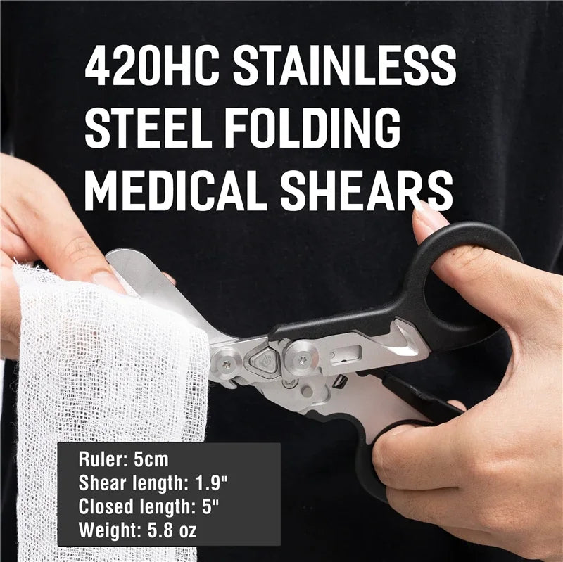 A hand holds a 420HC stainless steel folding medical shear with a ruler for scale.