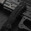 A close-up view of a black multi-functional camping survival knife with a textured handle and blade visible.