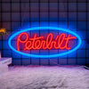 A bright red neon sign spelling 'Peterbilt' is mounted on a dark blue tiled wall.