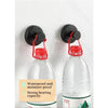 Two black suction cup hooks are mounted on a white wall, with bottles visible below them.