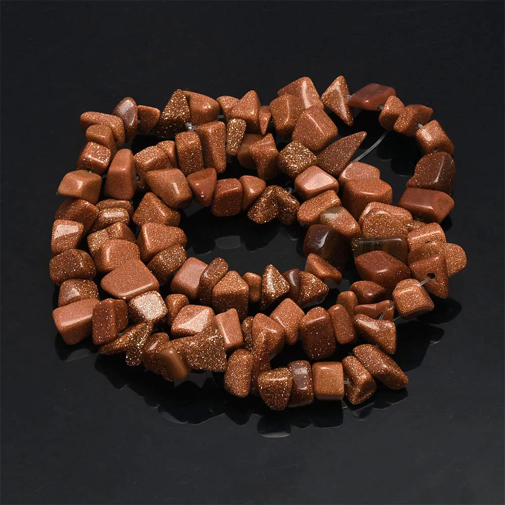 A collection of natural, reddish-brown, sparkling agate beads arranged in a circular pattern.