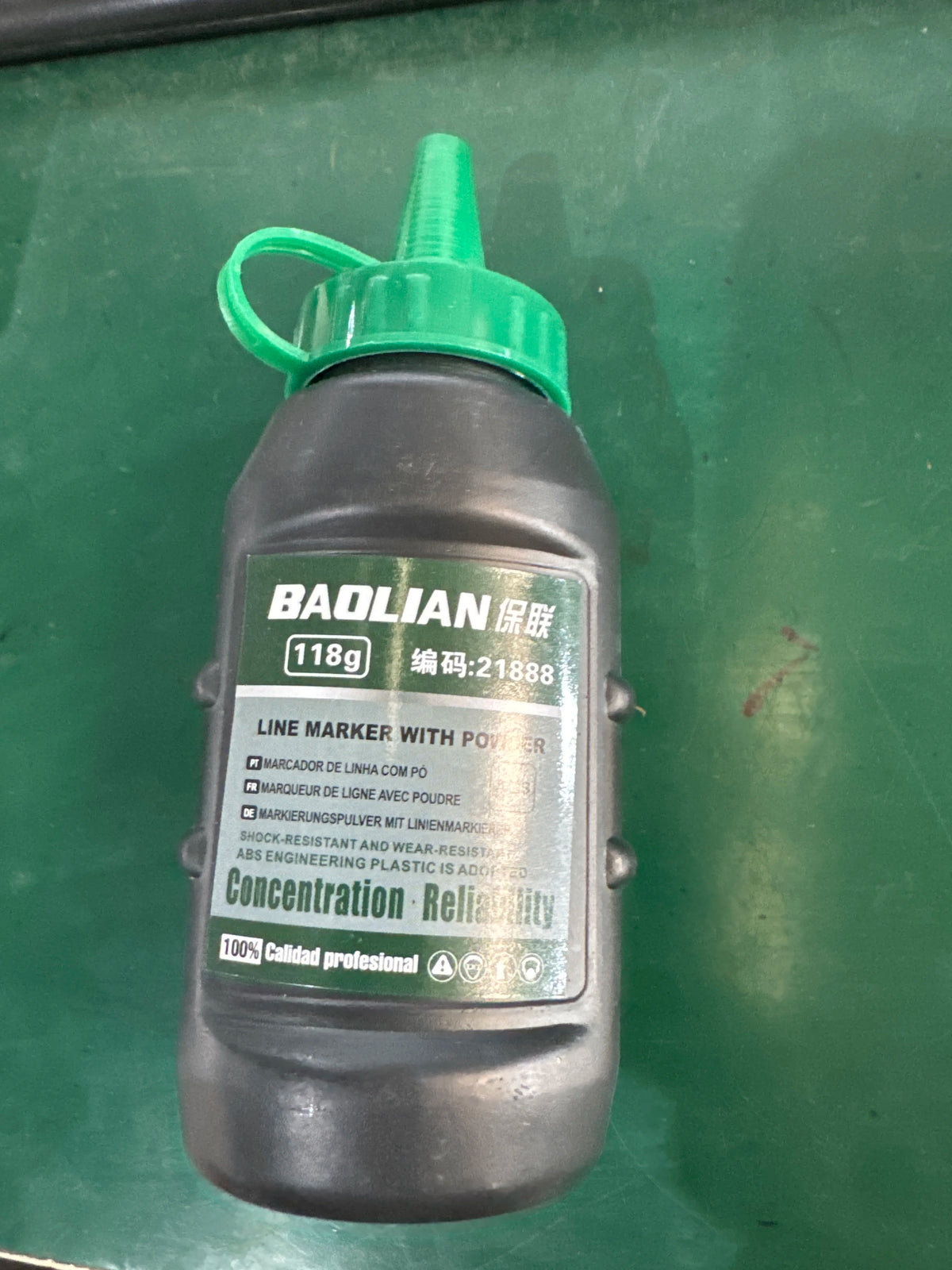 A dark plastic bottle with a green cap and a liquid, labeled BAOLIAN LINE MARKER 118g.