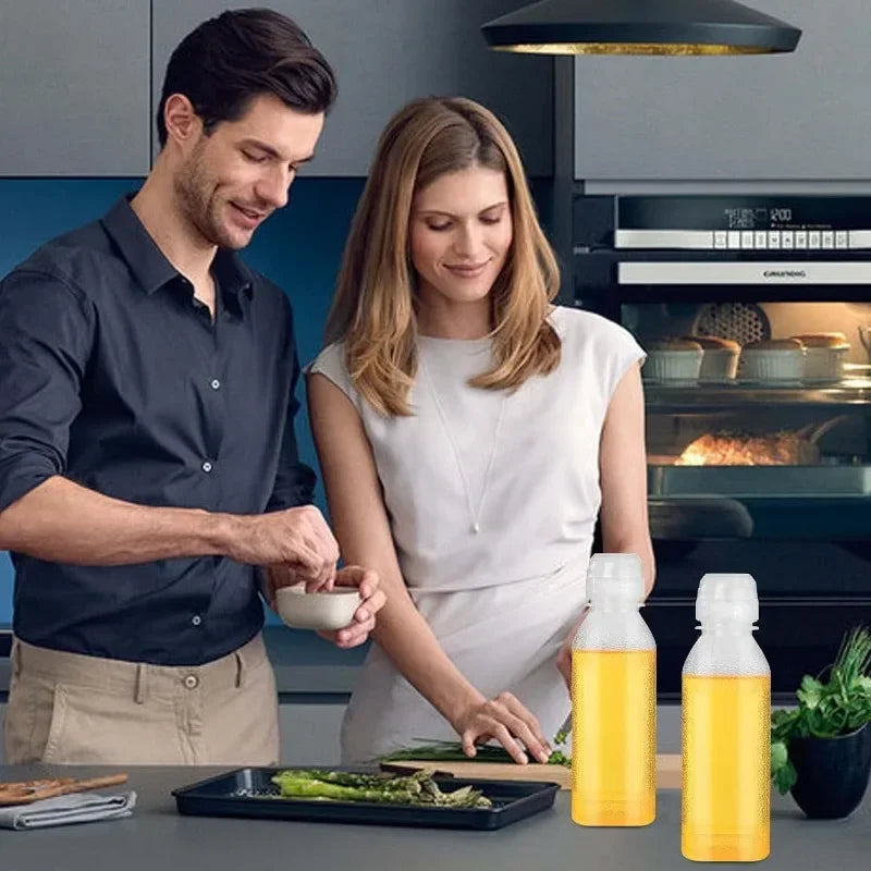 A man and a woman prepare food in a kitchen, with a yellow squeeze dispenser bottle for seasoning on the counter.