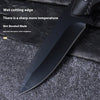 A black stainless steel fixed blade camping knife with a wet cutting edge resting on a dark textured surface.