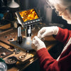 Una persona con guantes está usando un microscopio digital 1000X para inspeccionar objetos metálicos pequeños.