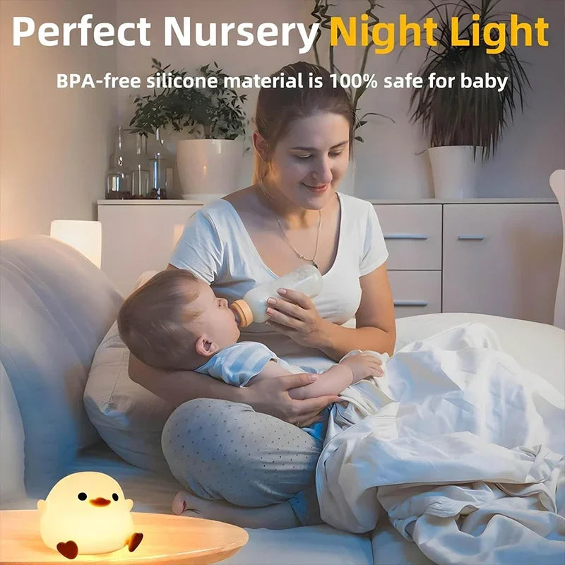 Eine Frau hält ein Baby und benutzt eine Silikon-Enten-Nachtlampe in einem hellen Innenraum.