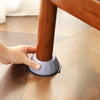 A hand is pressing a silicone foot pad onto the base of a wooden furniture leg.