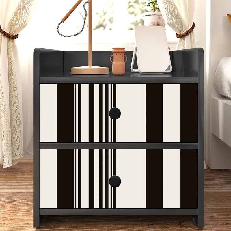 A black storage cabinet with two drawers featuring decorative vertical vinyl wall strips in black and white.