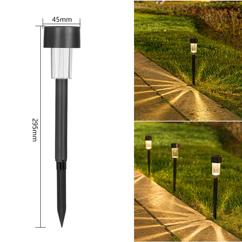 A black solar powered outdoor garden lantern with a clear glass shade mounted on a long stake.