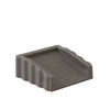 A gray reusable TPR door stop wedge with ribbed texture.