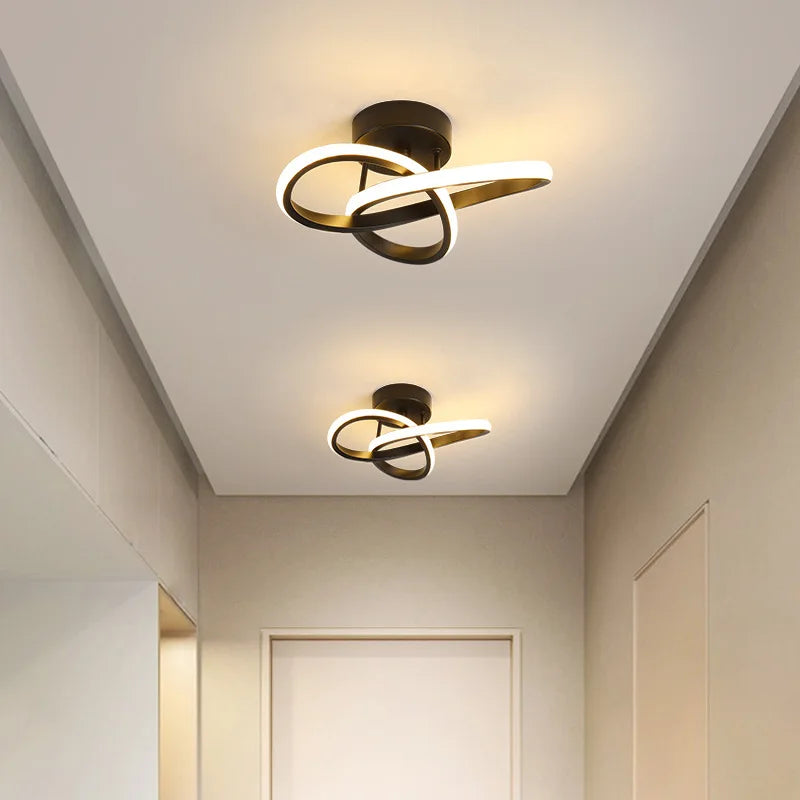 Modern LED ceiling light fixture with a gold and black abstract ring design mounted on a white ceiling.